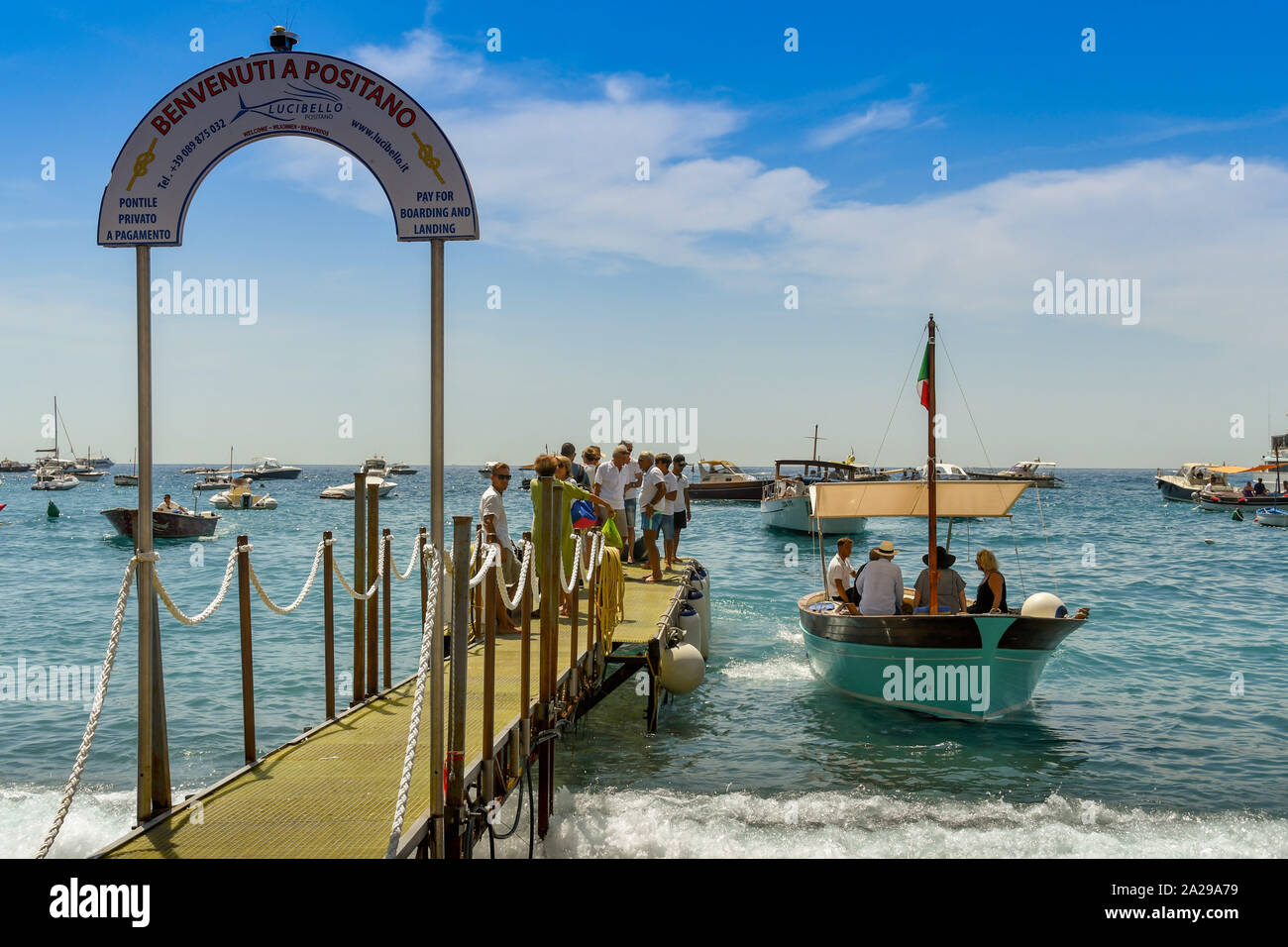 POSITANO, ITALIEN - AUGUST 2019: Menschen warten auf ein eigenes Motorboot auf dem Bootssteg board in Positano. Stockfoto