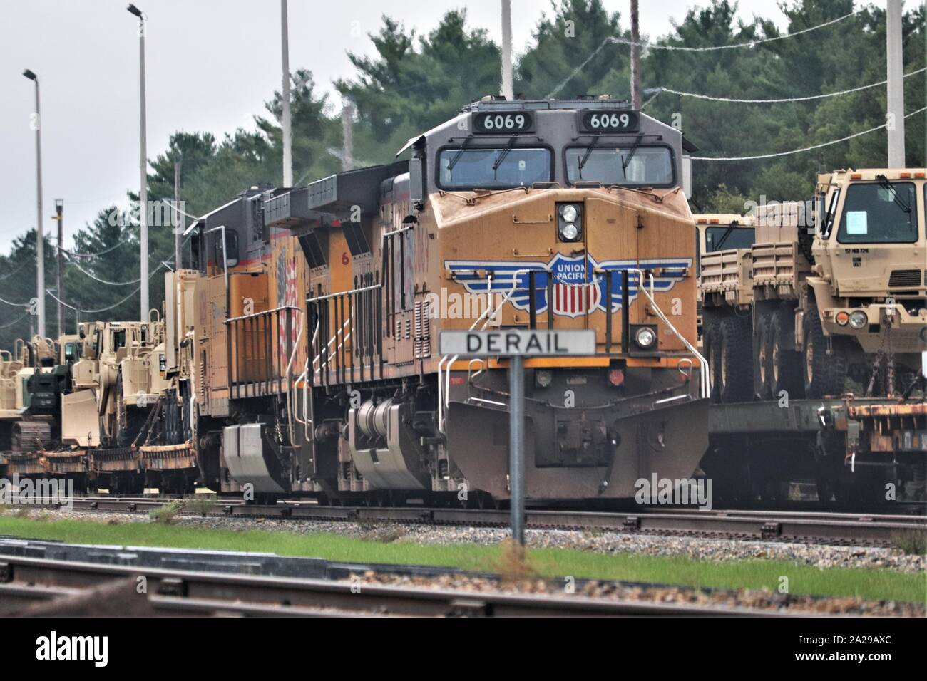 Eine Lokomotive für die canadian-pacific Eisenbahn ist auf einer Seite der Bahn zwischen beweglichen triebwagen Sept. 27, 2019, am Fort McCoy, Wis militärische Fahrzeuge und Ausrüstungsgegenstände von der 829th Engineer Unternehmen wurden auf Triebwagen für eine ausländische Einsatz später im Jahr versendet werden geladen geparkt. Die Schiene wird geladen und die damit verbundenen Arbeiten wurde von der 829Th und Mitarbeiter mit der Festung McCoy Logistics Readiness Center Transport Division abgeschlossen. (U.S. Armee Foto von Scott T. Sturkol, Public Affairs Office, Fort McCoy, Wis.) Stockfoto