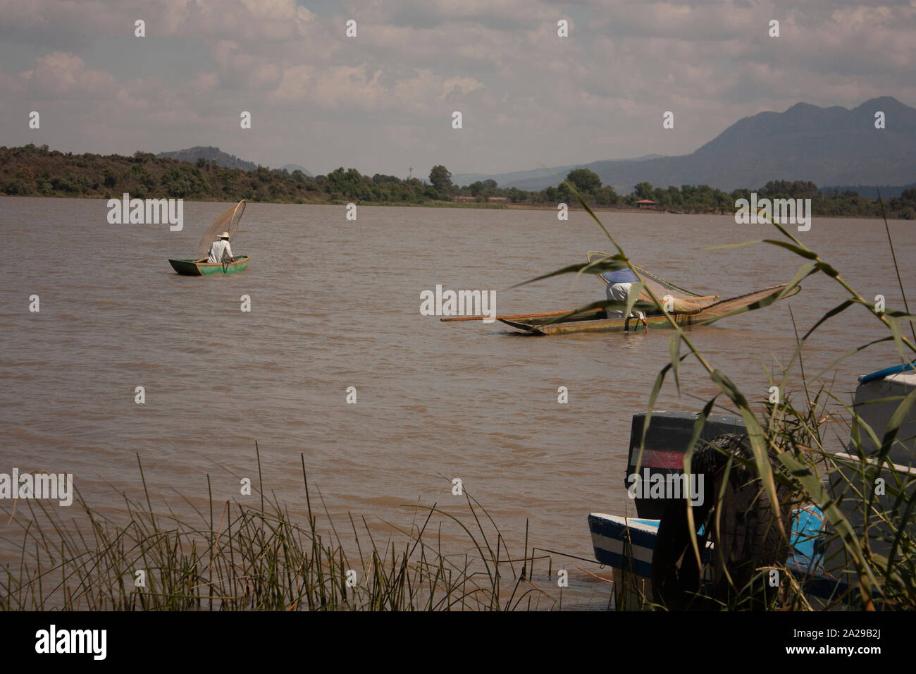 Paar Fischer tragen weiße Decken und paddeln Hüte Segeln mit ihren Kanus beladen mit Moskitonetzen über See Mexiko Stockfoto