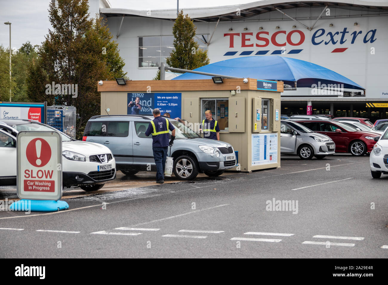 Teilnehmer das Waschen von Autos an einem Tesco Extra Auto waschen Service Bereich Stockfoto