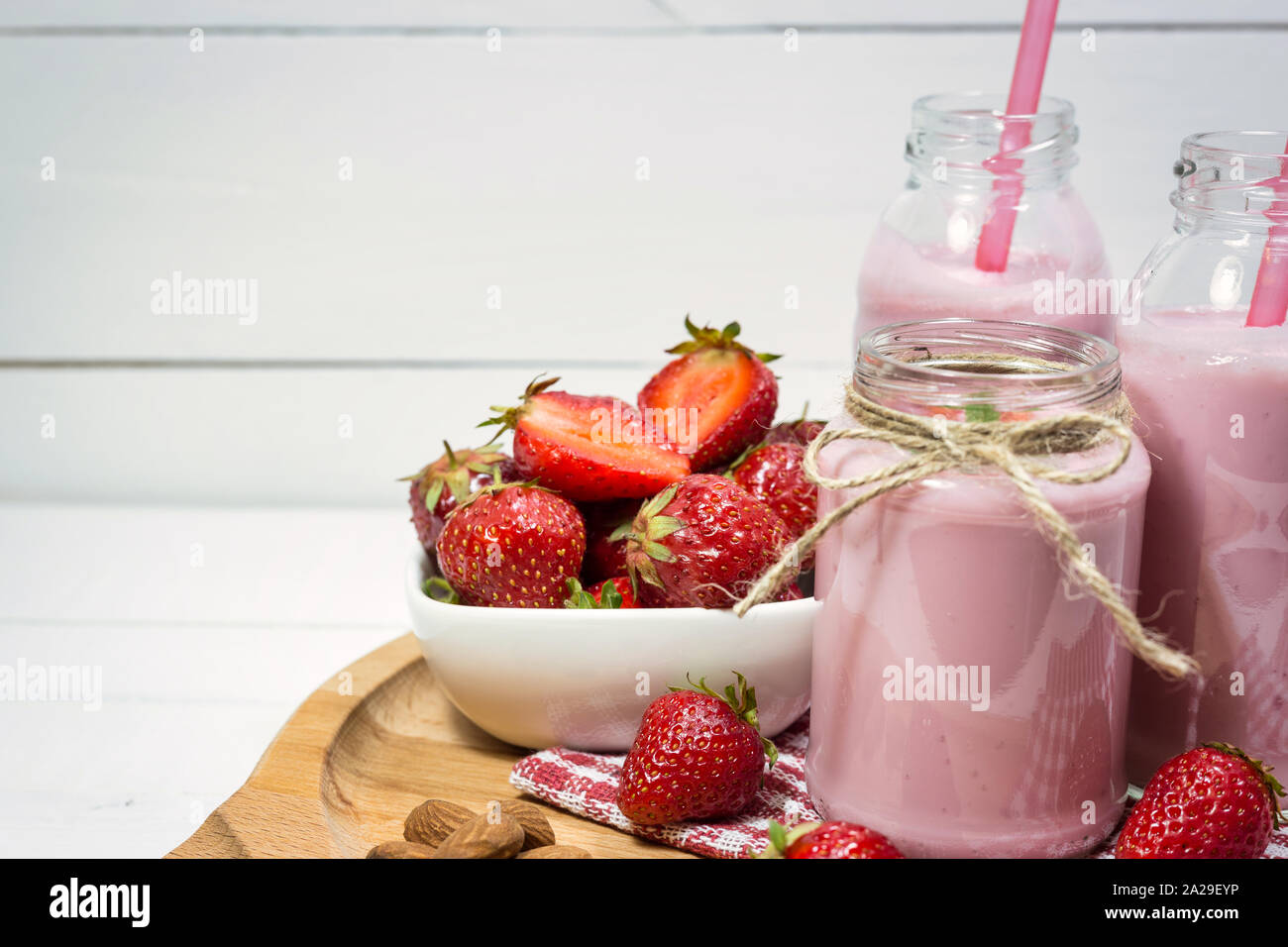 Frische Erdbeeren, Mandeln und hausgemachte Frucht Joghurt auf Holzplatte. Gesunde Ernährung Konzept. Stockfoto