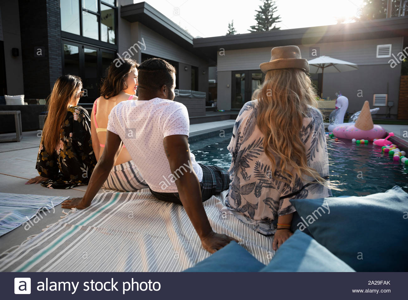 Junge Erwachsene Freunde entspannen im sonnigen Sommer am Pool Stockfoto