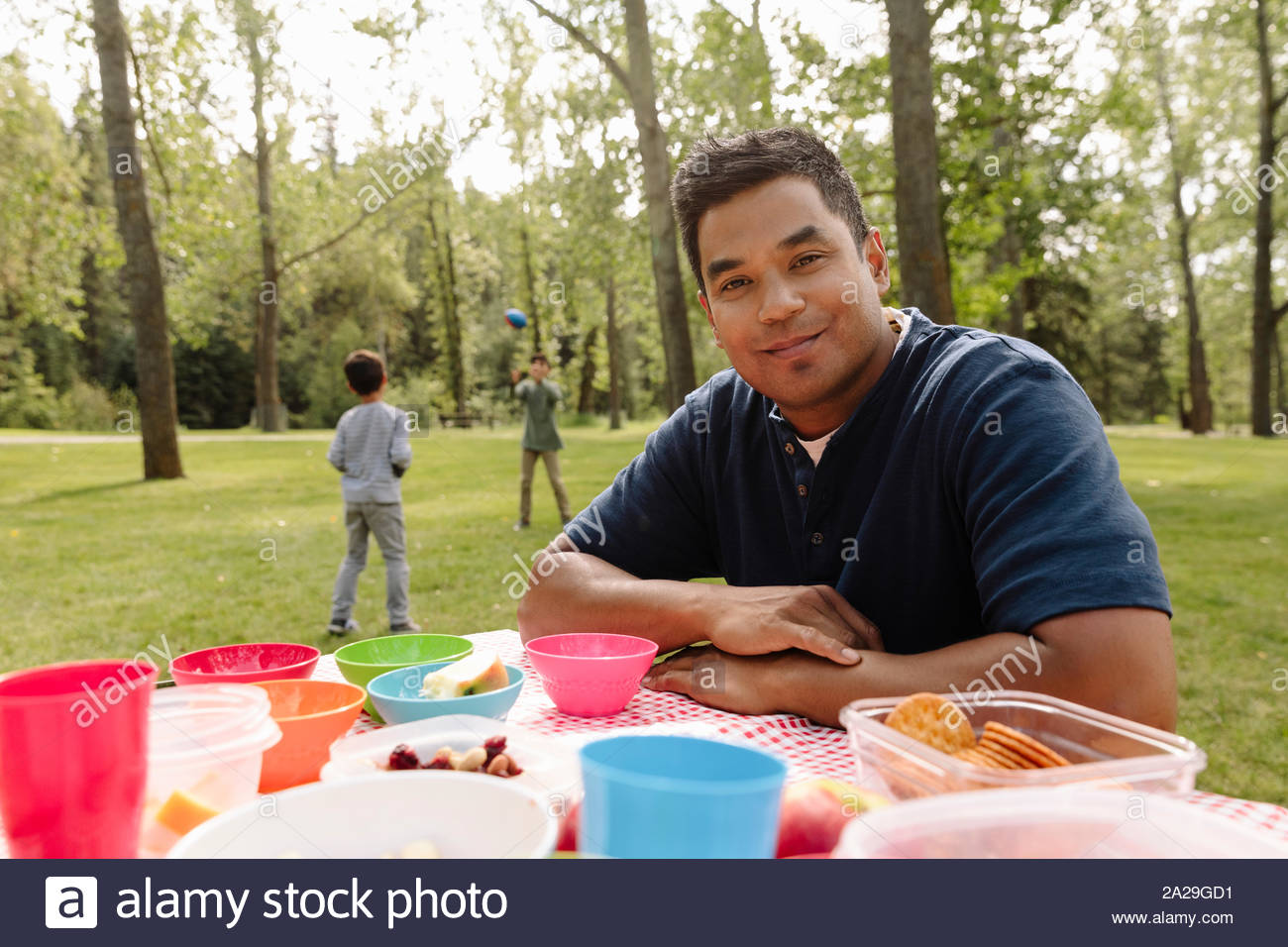 Portrait von Mensch, Picknick im Park mit Jungen spielen im Hintergrund Stockfoto