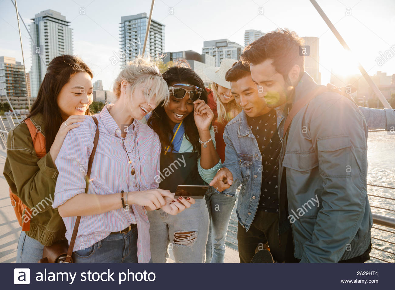 Glückliche junge erwachsene Freunde mit digitalen Tablet an sonnigen, städtische Brücke Stockfoto