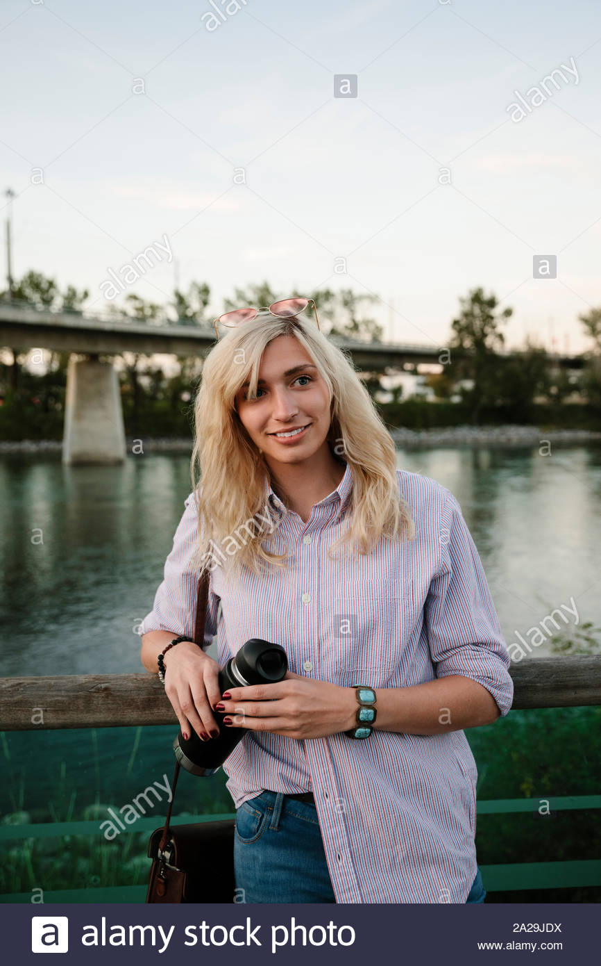 Junge Frau mit Wasserflasche im Waterfront Stockfoto