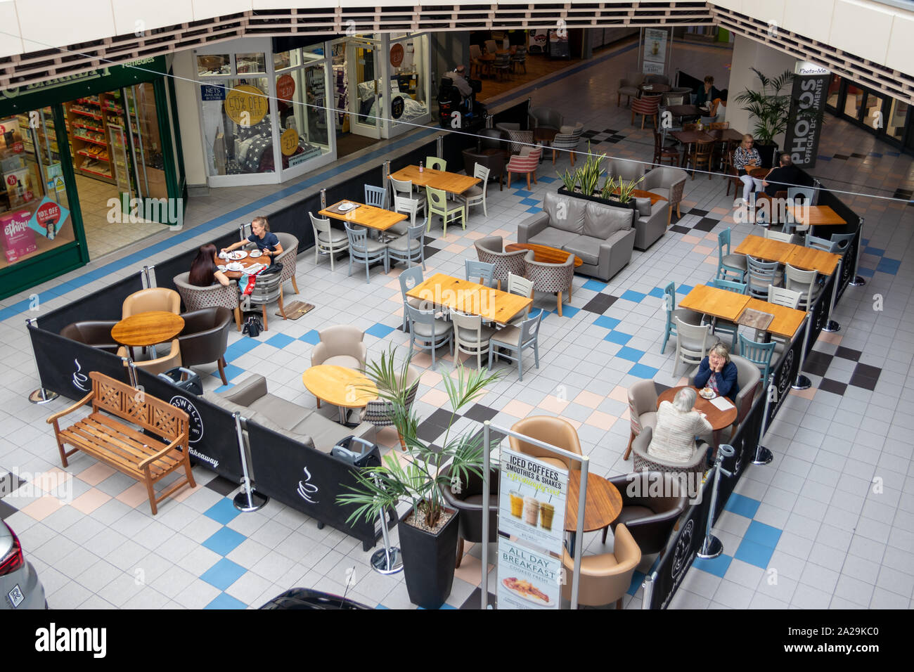 UK nach unten betrachten Menschen sassen an den Tischen essen und trinken zu einem Food Court in einem Einkaufszentrum oder im Einkaufszentrum Stockfoto
