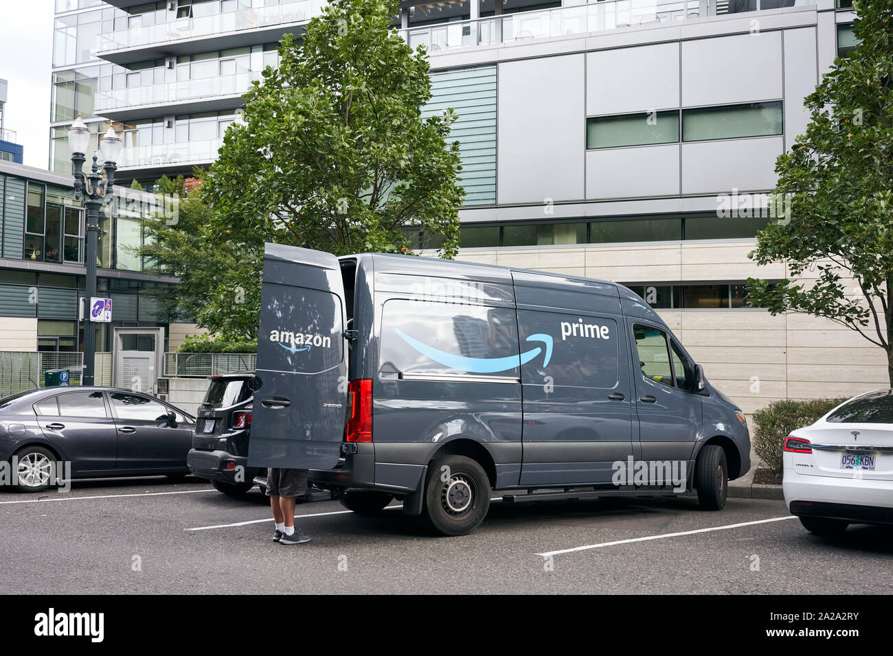 Portland, Oregon, USA - 13.September 2019: Ein Amazon Arbeitnehmer gesehen Entladen eines Amazon Prime Marke van am Straßenrand in der Innenstadt von Portland. Stockfoto