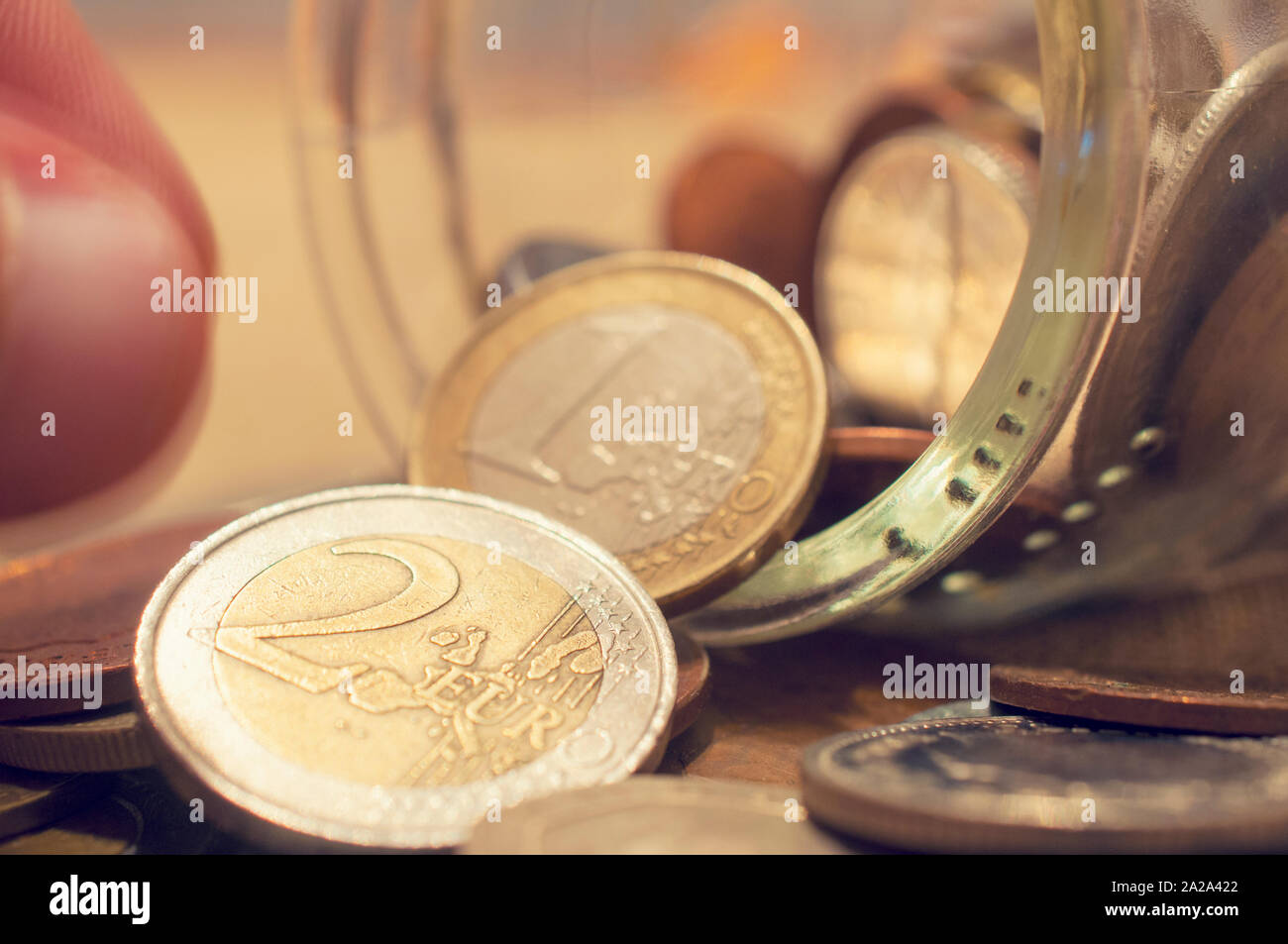 Hand die Münze aus einem umgestürzten Münze jar Stockfoto