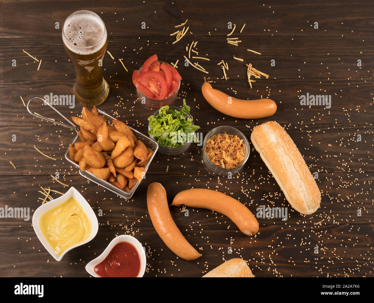 Heiße Hunde Gemüse, Soßen und Keile Pommes auf hölzernen Tisch Stockfoto