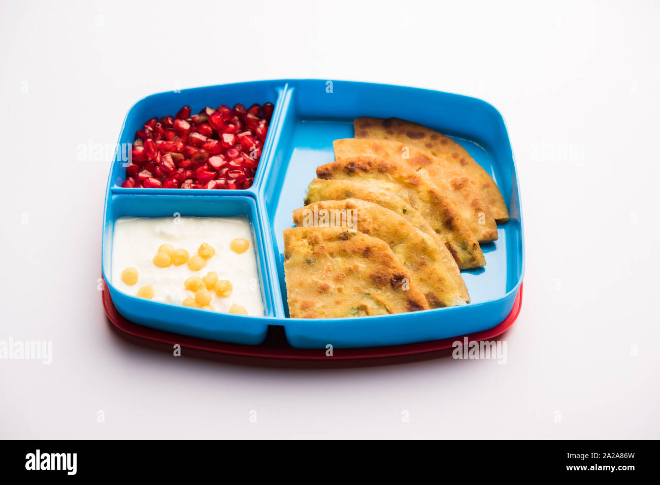 Lunch Box/Tiffin für indische Kinder, umfasst Aloo Paratha, Quark boondi und Granatapfel Samen, selektiven Fokus Stockfoto