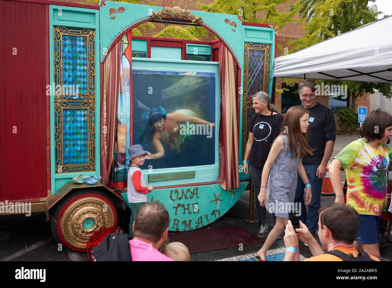 Ein Junge hat sein Foto mit einer Meerjungfrau Entertainer in der Portland Mini Maker Faire in OMSI, ein Museum in Portland, Oregon, am Sonntag, 8. September 2019 aufgenommen. Stockfoto