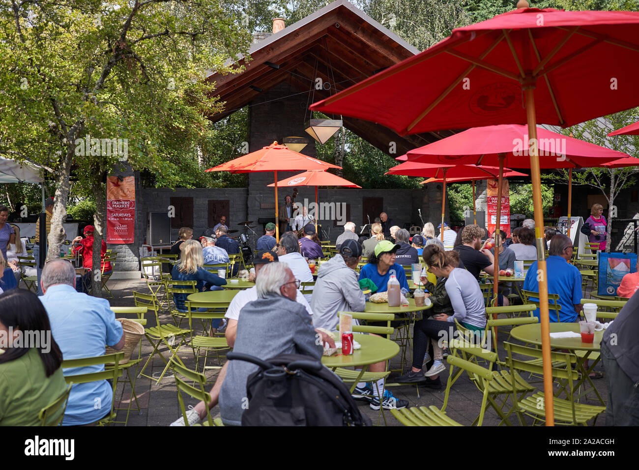 Menschen, die am 14. September 2019 in Lake Oswego, Oregon, Essen und Live-Musik in einem Sitzbereich im Freien auf dem Samstagsmarkt genießen. Stockfoto