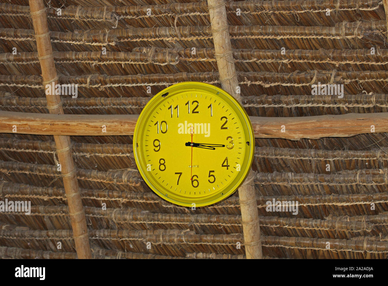 Strohdach Decke mit einer Uhr in der it, Sansibar, Unguja Insel, Tansania. Stockfoto