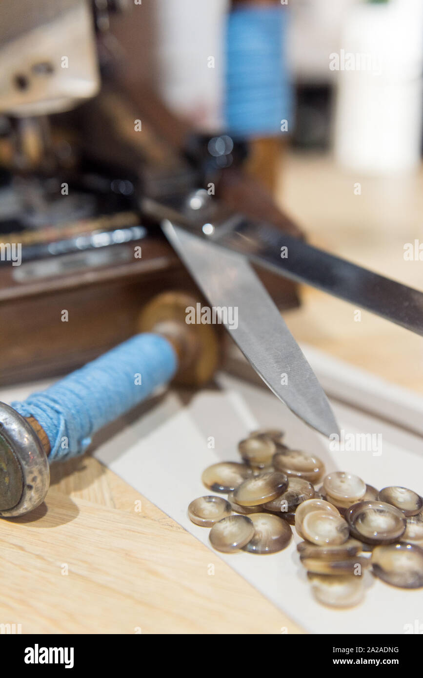 Anpassen der Schere, Tasten und blauem Garn neben Alte Nähmaschine Stockfoto