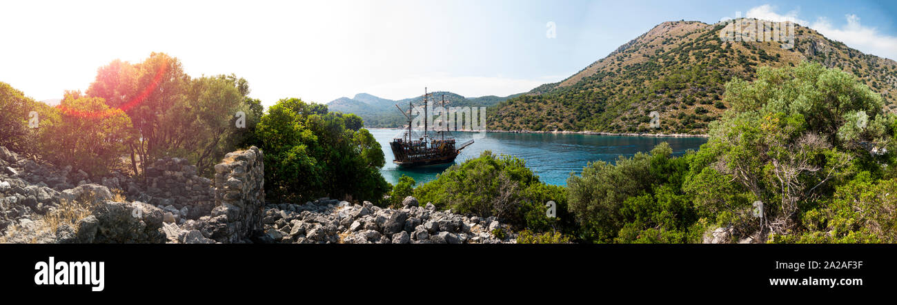 Panoramablick von Segelschiff in einer Bucht, umgeben von alten Ruinen günstig Stockfoto