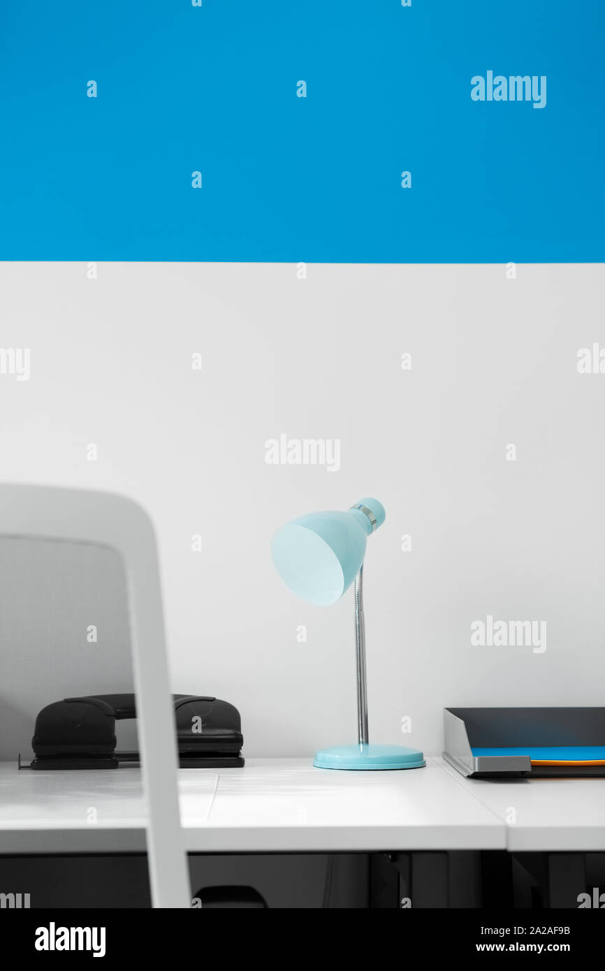 Modernen Schreibtisch und blauen Lampe in einem Home Office Stockfoto