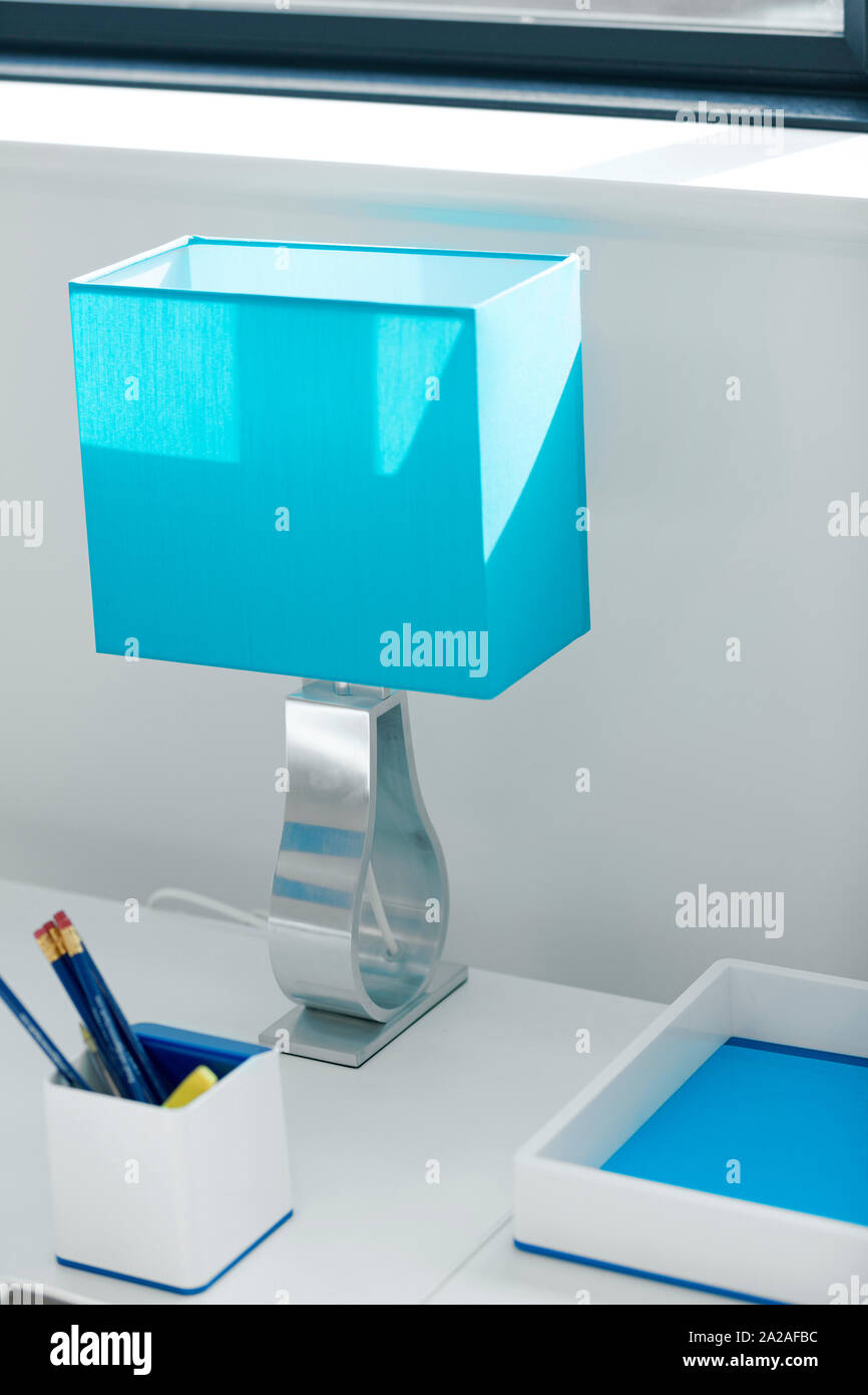 Modernen Schreibtisch und blauen Lampe in einem Home Office Stockfoto