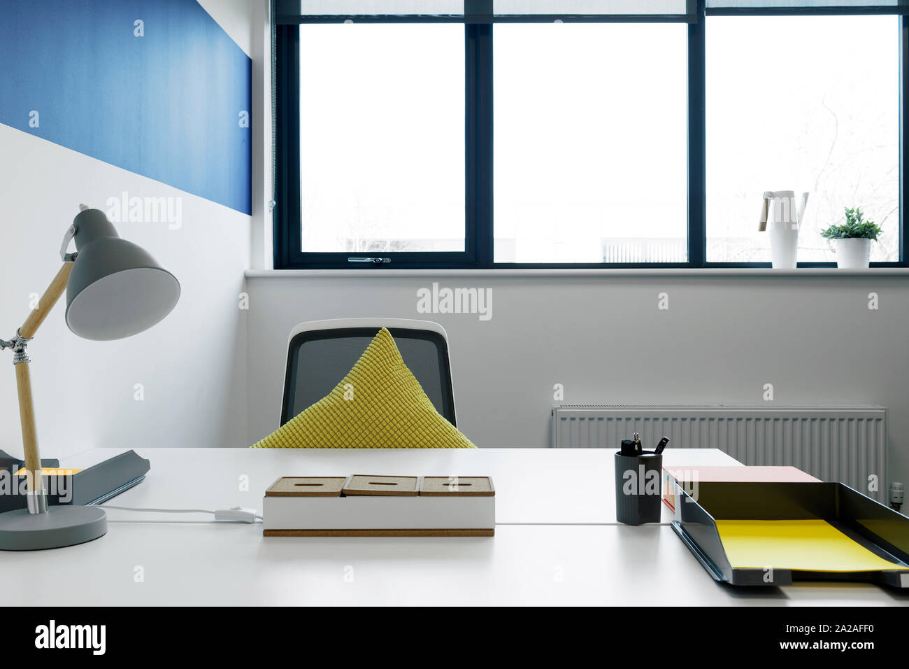 Modernen Schreibtisch und blauen Lampe in einem Büro Stockfoto