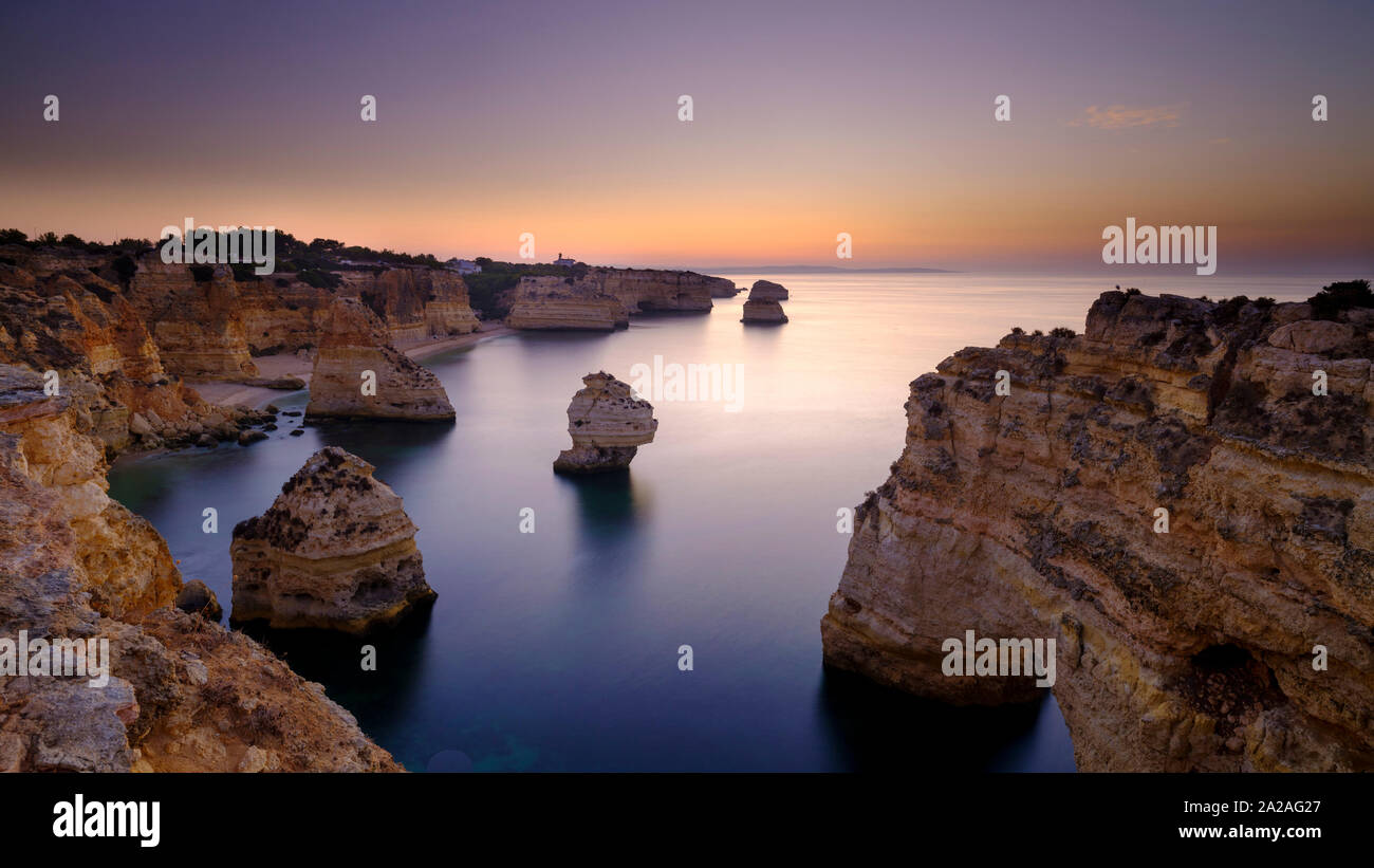 Faro, Portugal - 18. September 2019: Blaue Stunde Sonnenaufgang und entlang der Küste der Algarve in Richtung Faro von den Klippen oberhalb von Praia da Marinha, Portugal Stockfoto