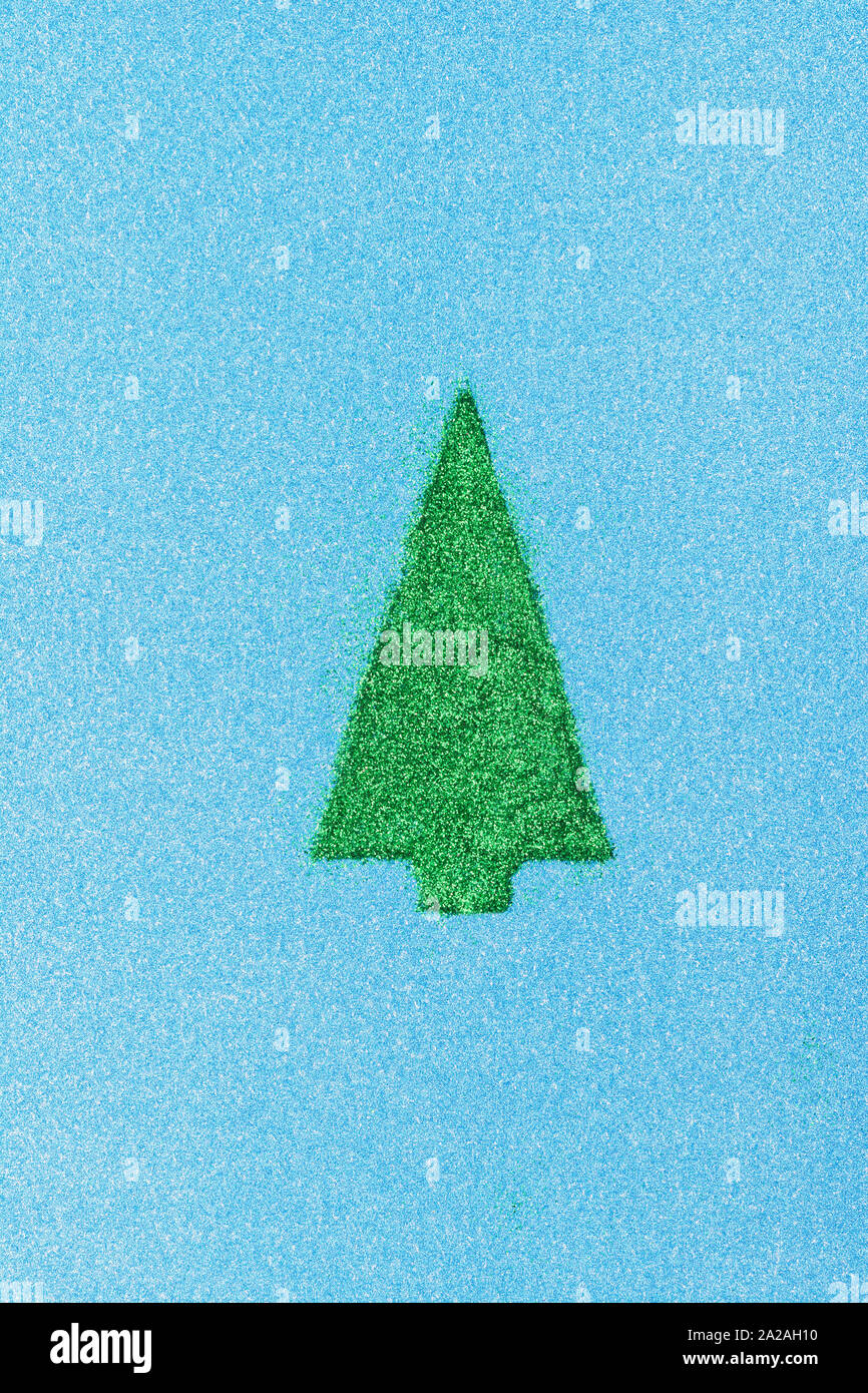 Grüner Weihnachtsbaum Form aus Glitzer auf glitzernd blauen Papier, selektiver Fokus Stockfoto