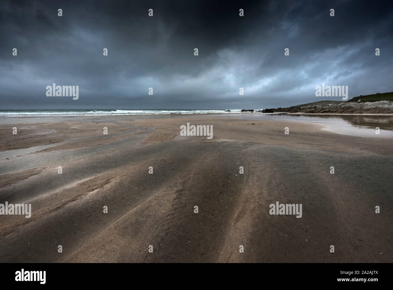 Dunkle dramatische Kühle herbstliche Wetter über eine einsame Fistral Beach in Newquay in Cornwall. Stockfoto