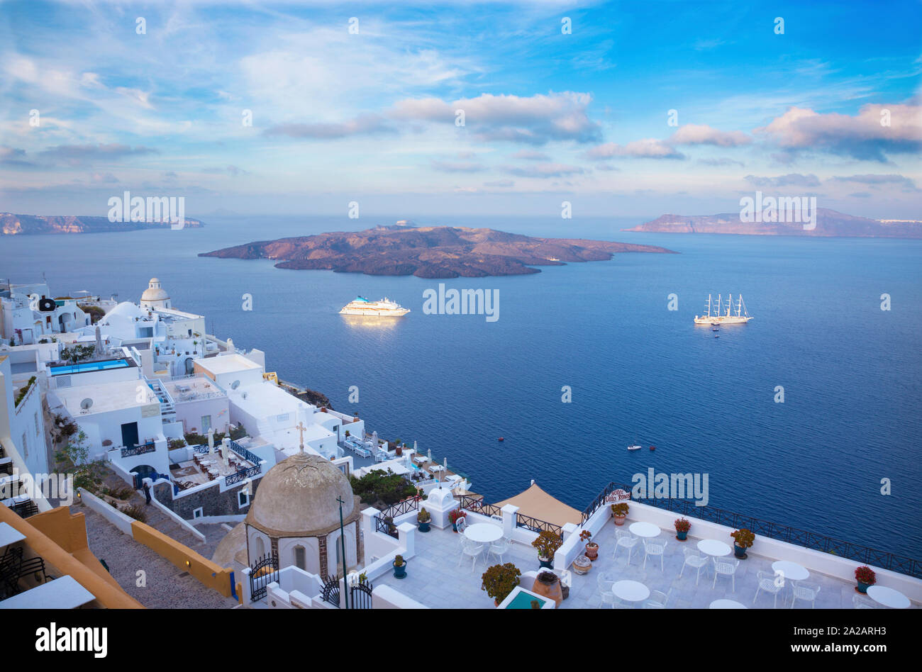 Santorini - die Aussichten von Fira nach Caldera mit der Nea Kameni Insel im Morgenlicht. Stockfoto