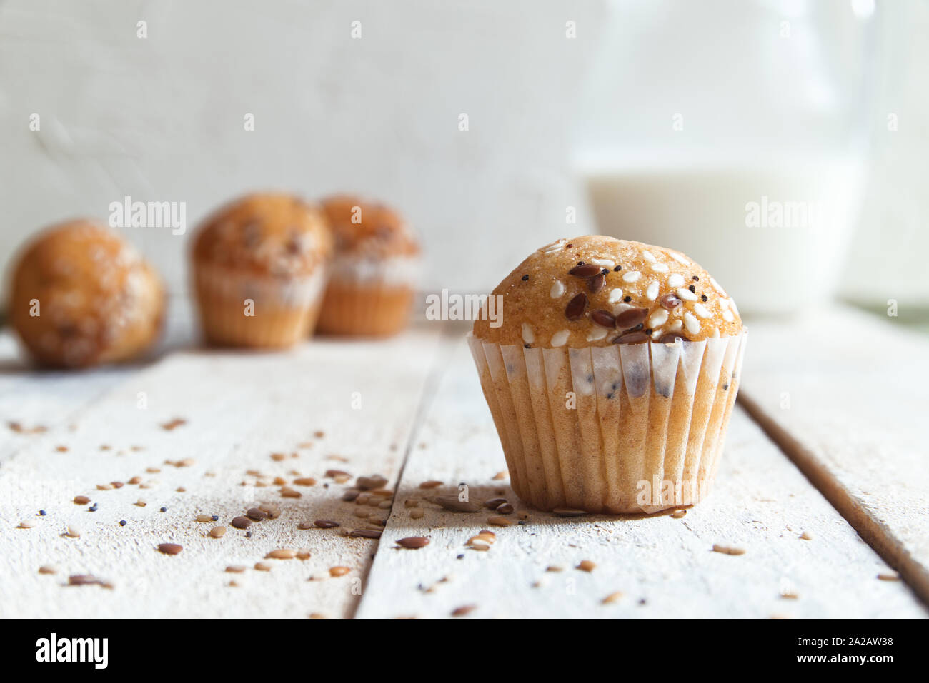 Fee Kuchen mit einigen sessame Samen auf eine weiße Holztisch vor einem weißen Hintergrund in eine rustikale Küche. Glas Milch zum Frühstück Platz kopieren Stockfoto