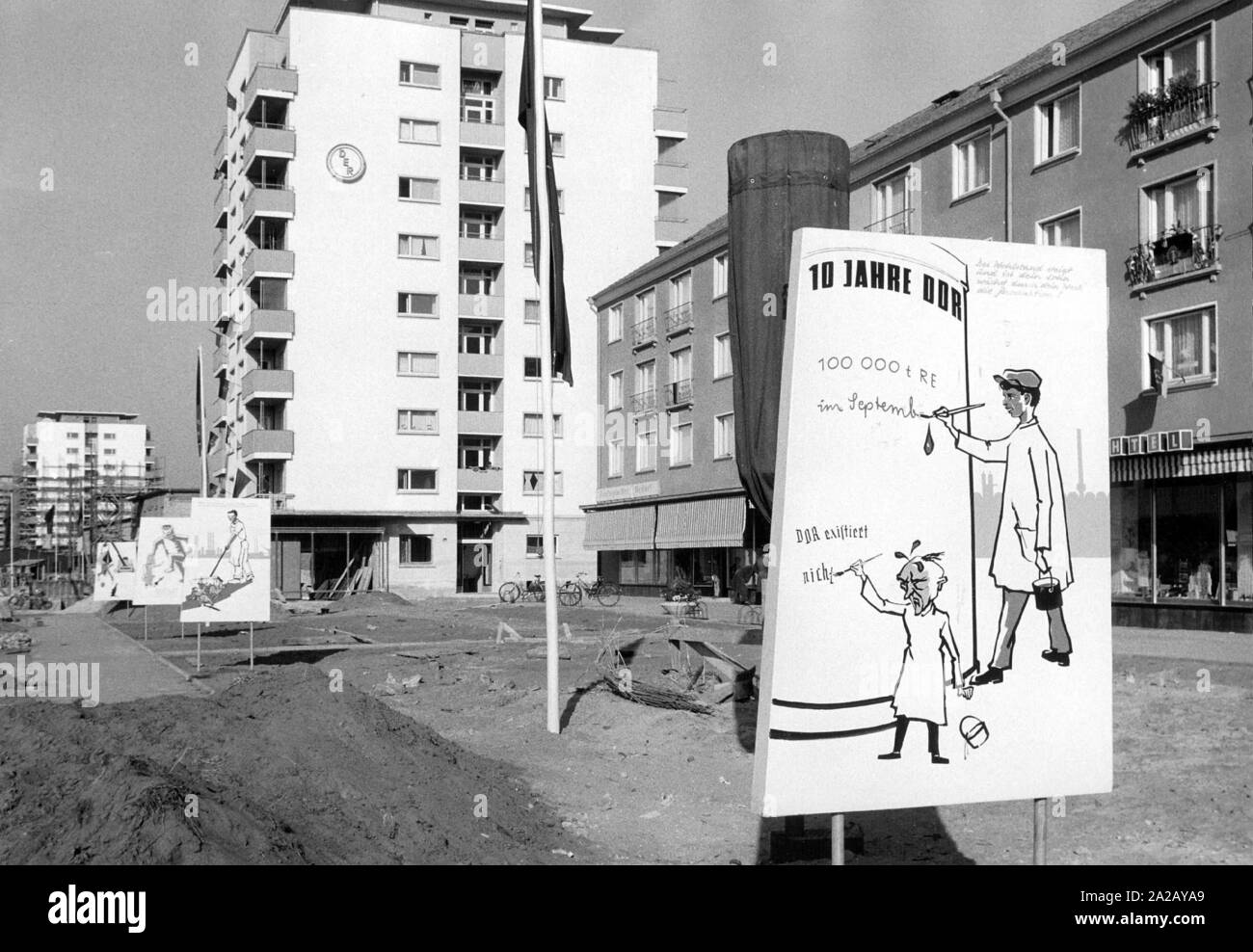 In einer Straße von Stalinstadt ein Comic, der 10. Jahrestag der DDR feiert - und ruft den Geist von Bundeskanzler Konrad Adenauer ihre Existenz. Stockfoto