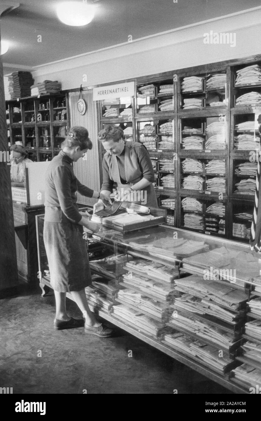 Ein Kunde und ein Verkäufer in einem teilweise verstaatlicht Stoff shop in Weimar. Stockfoto