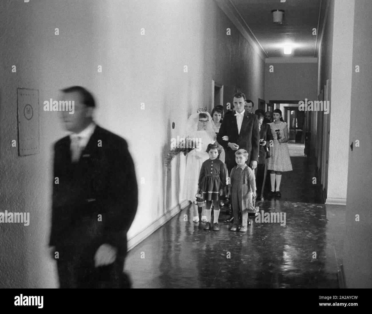 Braut und Bräutigam mit Hochzeit Party in Stalinstadt, DDR. Vor der Hochzeit paar, zwei Kinder mit Blumenkörben. Stockfoto