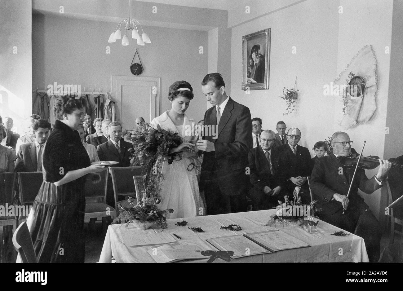 Braut und Bräutigam bei der sozialistischen Trauung in Dresden, Ostdeutschland. Der Bräutigam stellt den Ehering am Finger des Braut. Stockfoto