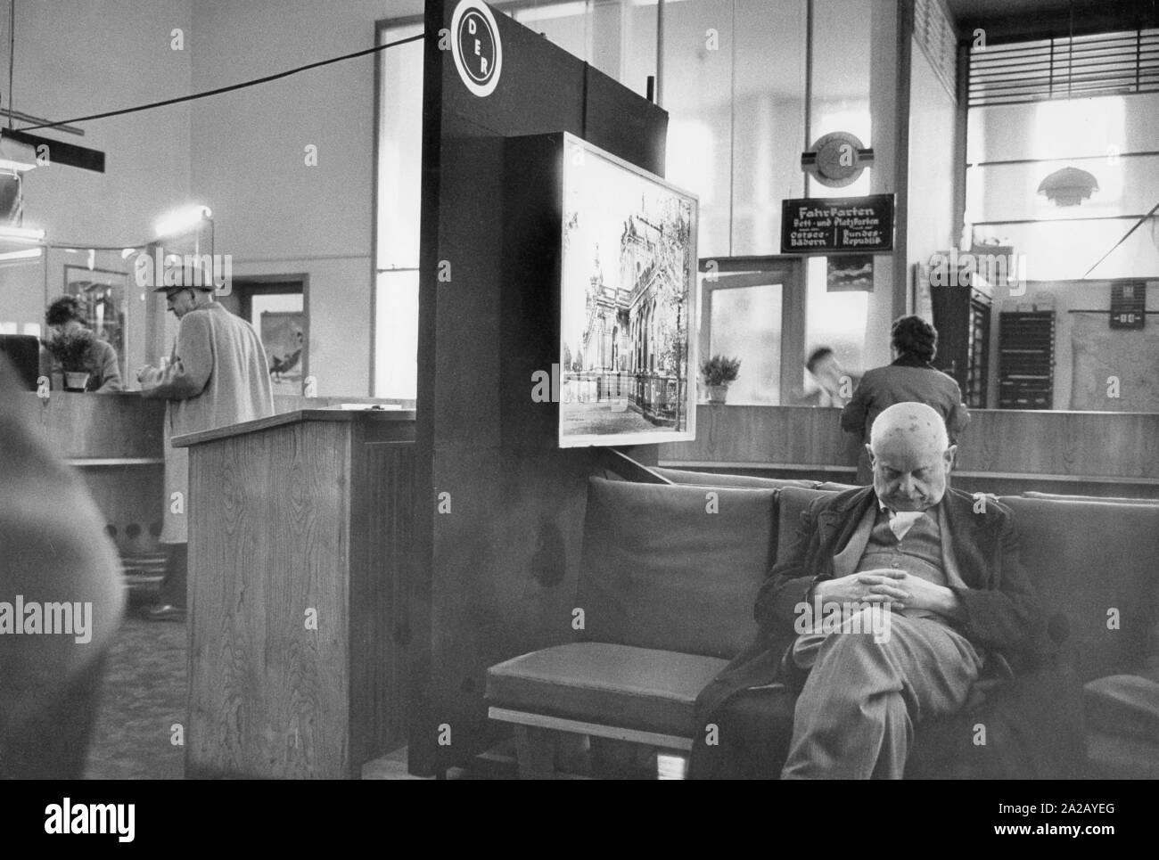 Szene in einem Tourist Office in Leipzig, im Vordergrund ein alter Mann schlief auf der Richtbank. Stockfoto