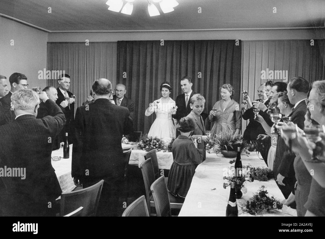 Braut und Bräutigam bei der sozialistischen Trauung in Dresden, Ostdeutschland. Brautpaar und Hochzeitsgäste trinkt ein Toast. Stockfoto