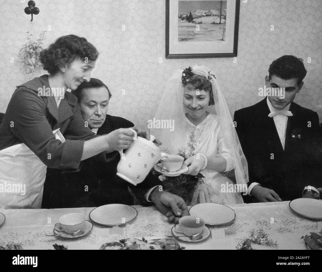 Brautpaar mit Kaffee und Kuchen in der elterlichen Wohnung nach der kirchlichen Trauung in der St. Georg Kirche in Berlin-Pankow, Ostdeutschland. Stockfoto