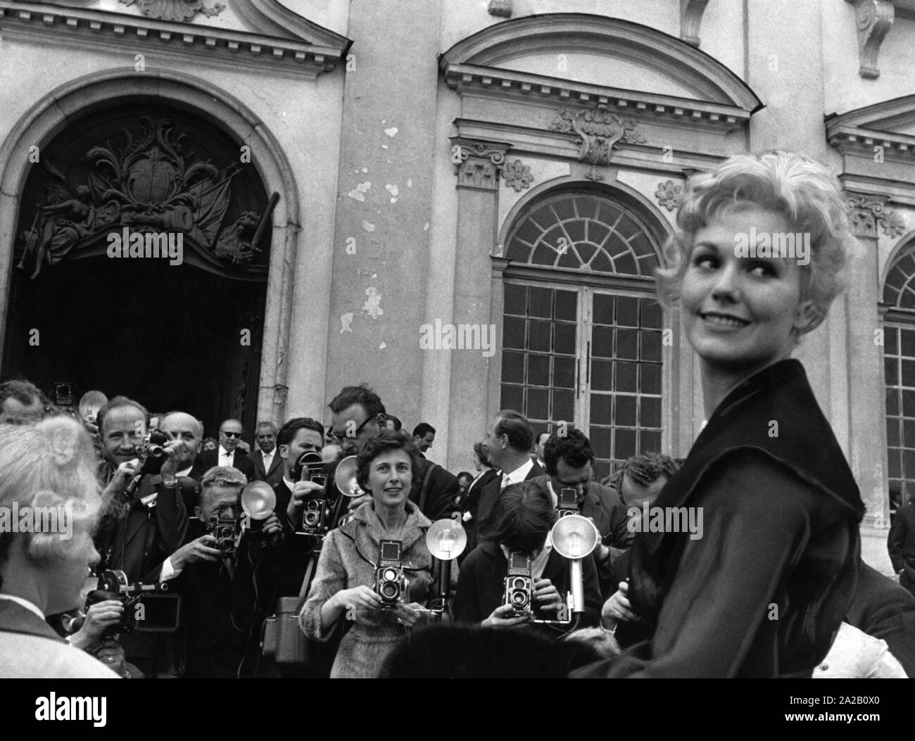 Im Juni 1959, Kim Novak besuchten das Schloss Schleißheim in München. Es war eine Art PR-Veranstaltung, an der zahlreiche Vertreter aus der Film- und Filmindustrie sowie Dutzende drücken Sie Leute eingeladen wurden. Das Bild zeigt Kim Novak, in einer Kutsche zum Schloss. Sie wird von den zahlreichen Fans und Fotografen umgeben. Stockfoto