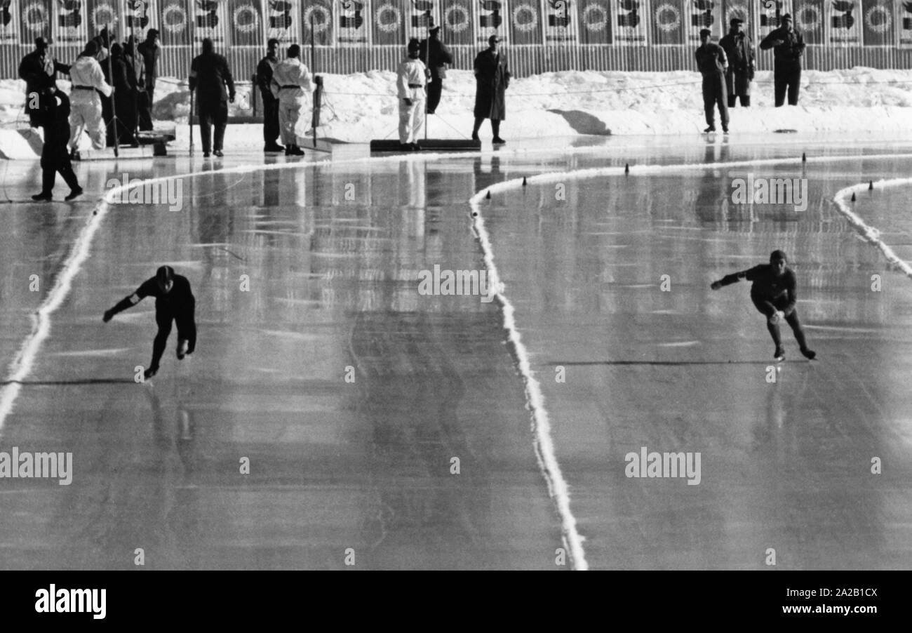 Das Bild zeigt einen der 500 Meter läuft bei den Olympischen Winterspielen 1956 in Cortina d'Ampezzo. Auf der linken Spur fährt die Zukunft Goldmedaillengewinner aus der UDSSR, Jewgeni Grischin. Die Speed skating Rennen wurden auf dem zugefrorenen See Misurina statt. Stockfoto