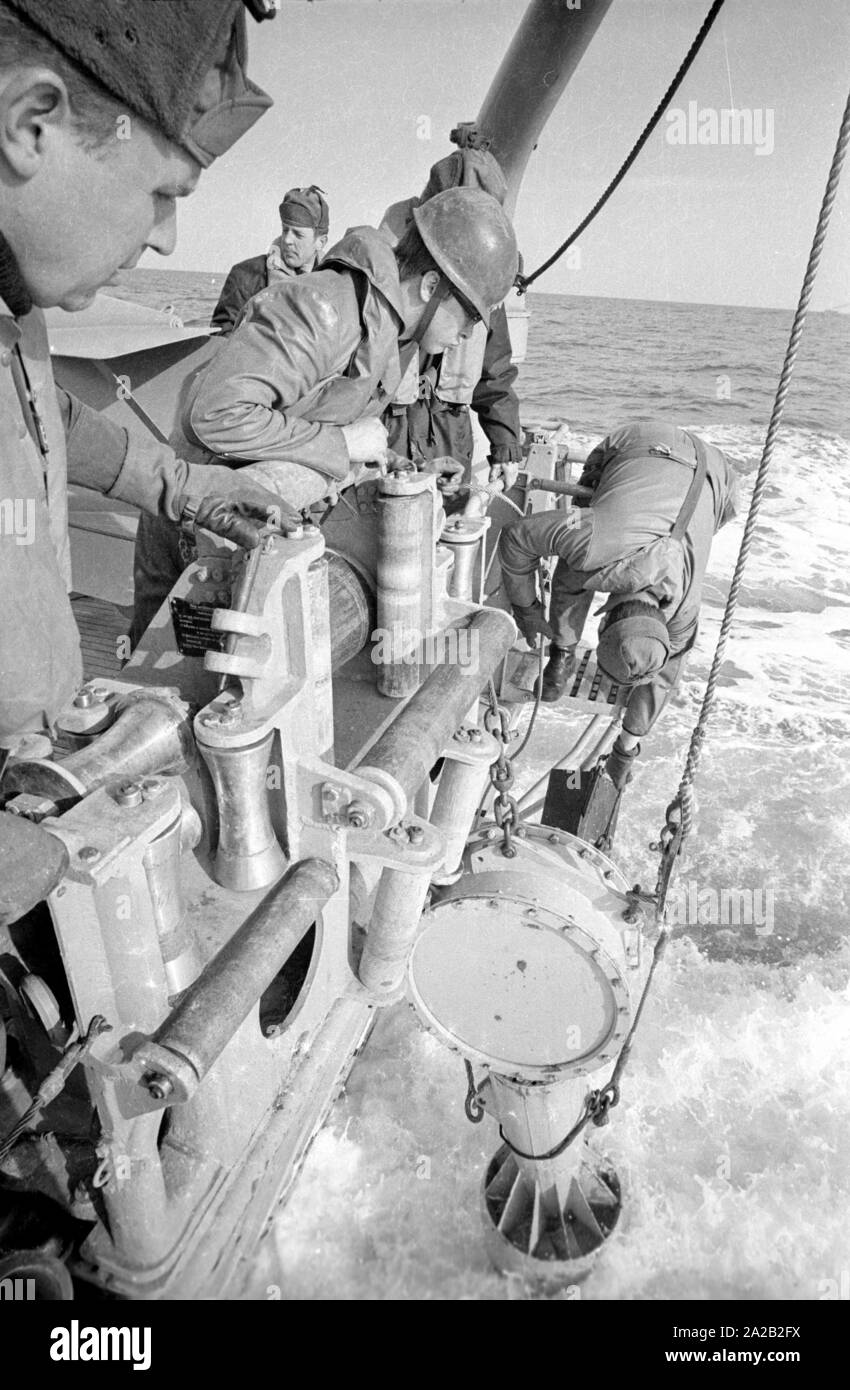 Die lindauer Klasse Coastal minehunter während einer Übung der 6. Minensuchgeschwader (6. Mine fegen Squadron) in der Nordsee. Soldaten bei der Arbeit auf der minesweeping Gang der Minesweeper. Hier Soldaten ziehen sich eine sonobuoy für Clearing Seeminen mit einem akustischen Detonator. Stockfoto Die lindauer Klasse Coastal minehunter während einer Übung der 6. Minensuchgeschwader (6. Mine fegen Squadron) in der Nordsee. Soldaten bei der Arbeit auf der minesweeping Gang der Minesweeper. Hier Soldaten ziehen sich eine sonobuoy für Clearing Seeminen mit einem akustischen Detonator. Stockfoto