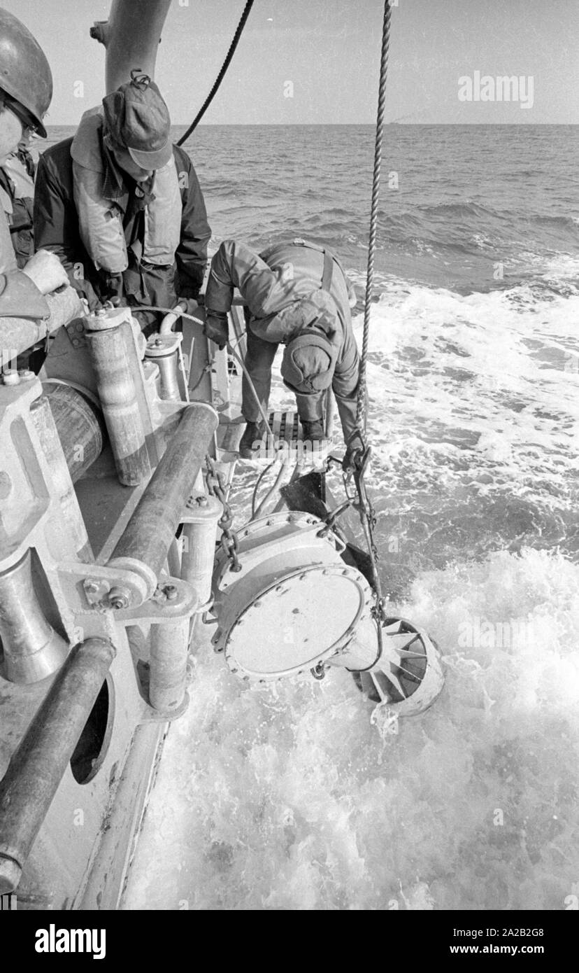Die lindauer Klasse Coastal minehunter während einer Übung der 6. Minensuchgeschwader (6. Mine fegen Squadron) in der Nordsee. Soldaten bei der Arbeit auf der minesweeping Gang der Minesweeper. Hier Soldaten ziehen sich eine sonobuoy für Clearing Seeminen mit einem akustischen Detonator. Stockfoto Die lindauer Klasse Coastal minehunter während einer Übung der 6. Minensuchgeschwader (6. Mine fegen Squadron) in der Nordsee. Soldaten bei der Arbeit auf der minesweeping Gang der Minesweeper. Hier Soldaten ziehen sich eine sonobuoy für Clearing Seeminen mit einem akustischen Detonator. Stockfoto