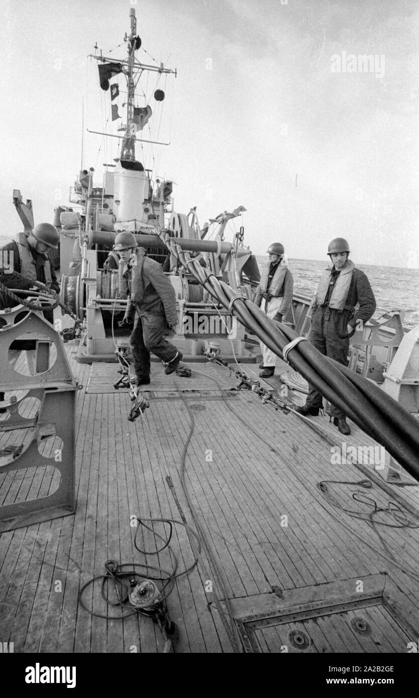 Die lindauer Klasse Coastal minehunter während einer Übung der 6. Minensuchgeschwader (6. Mine fegen Squadron) in der Nordsee. Soldaten bei der Arbeit auf der minesweeping Gang der Minesweeper. Das Boot erzeugt ein elektromagnetisches Feld mit dem Kabel (Mitte) Boden gruben mit einer elektromagnetischen Detonator auszulösen, und um sie zu löschen. Stockfoto Die lindauer Klasse Coastal minehunter während einer Übung der 6. Minensuchgeschwader (6. Mine fegen Squadron) in der Nordsee. Soldaten bei der Arbeit auf der minesweeping Gang der Minesweeper. Das Boot erzeugt ein elektromagnetisches Feld mit dem Kabel (Mitte) Boden gruben mit einer elektromagnetischen Detonator auszulösen, und um sie zu löschen. Stockfoto