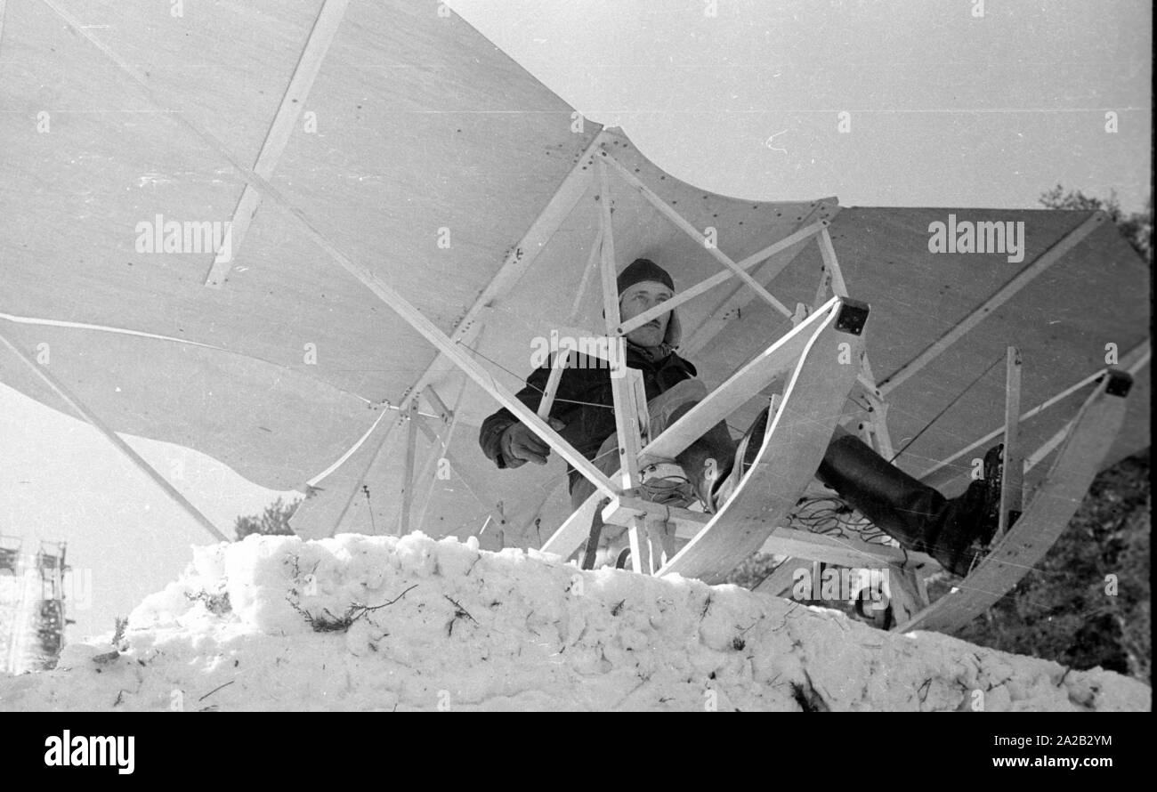 Das Bild zeigt die Hobby-Tüftler Hans Frank mit seiner Konstruktion, die sieht aus wie ein 'fliegenden Schlitten". Anscheinend wollte er seinen Bau am Hohenbogen Ski Jump in der Nähe von Neukirchen zu versuchen. Die Schanze wurde 1952 gebaut, aber ab 1959 keine regelmäßigen Wettbewerbe dort gehalten wurden, und die Schanze wurde in den 1960er Jahren abgerissen. Stockfoto