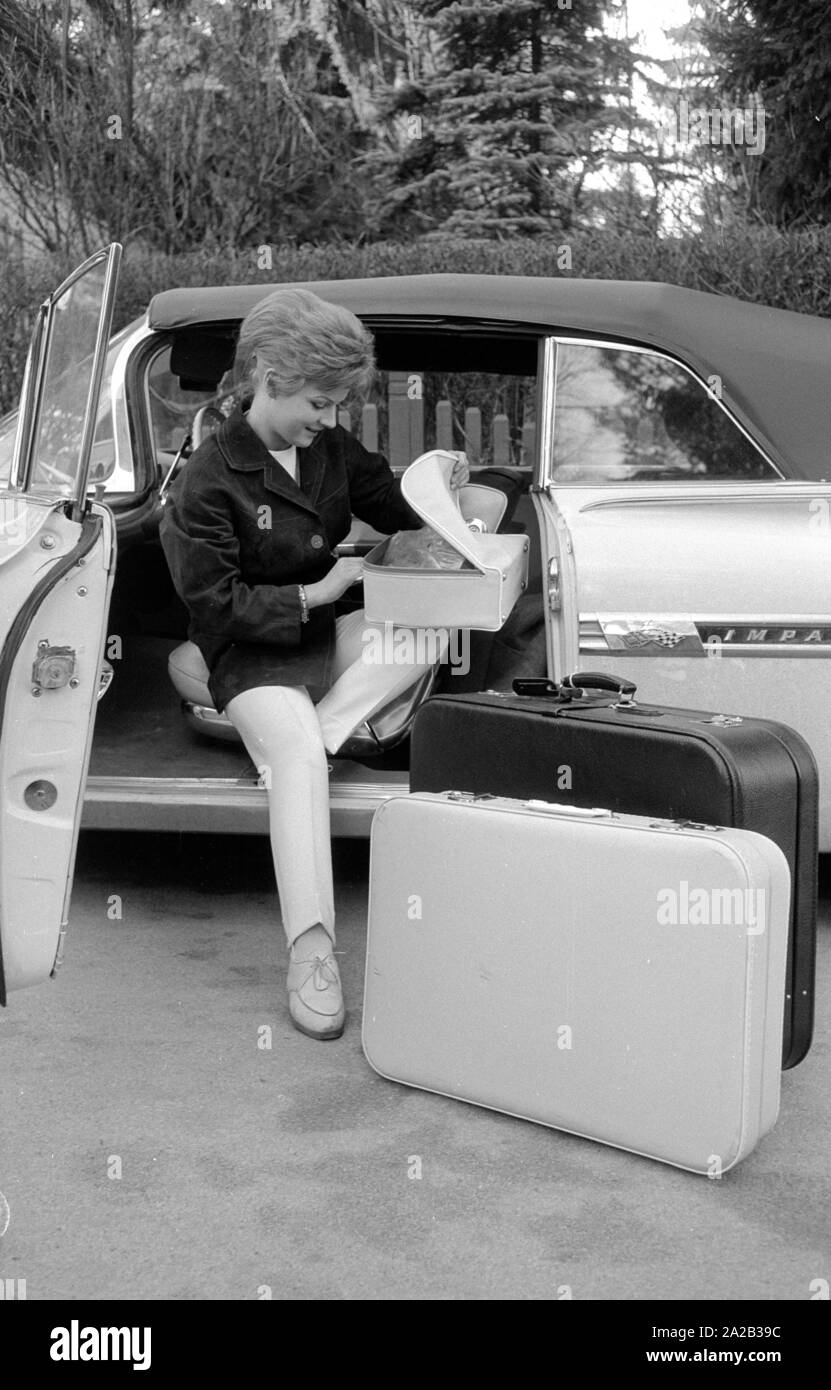 Die Schauspielerin und Sängerin Heidi Bruehl Entladen ein Auto. Sie sitzt seitlich am Fahrersitz und nimmt Ihr Gepäck aus dem Auto. Stockfoto