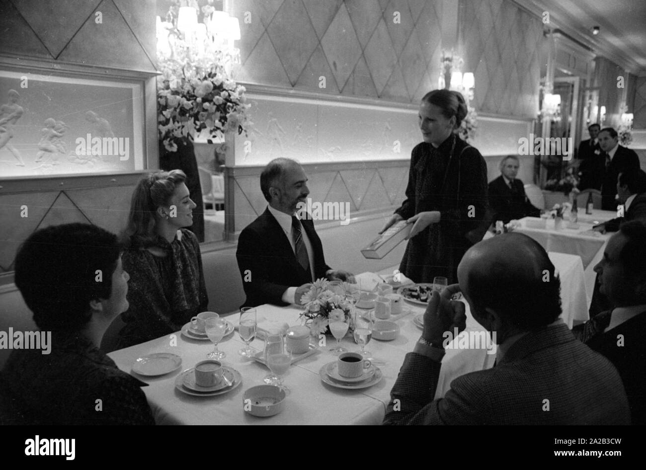 Nach einer diplomatischen Konferenz in Bonn, dem jordanischen König Hussein ich ein paar Tage in Berchtesgaden verbracht mit seiner Frau Königin Nur (zivile Name: Lisa Halaby), jedoch anlässlich seines Geburtstages sie im Hotel "Vier Jahreszeiten" in München verbracht. Das Bild zeigt das königliche Paar am Tisch mit Gästen, König Hussein erhält ein Geschenk. Stockfoto
