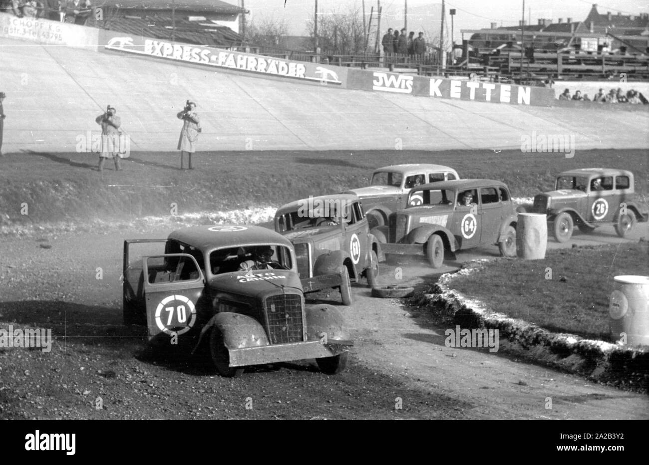 1954 ein Stock Car Rennen statt auf dem Münchner Amor-Bahn (eigentlich ein Radweg). Das Bild zeigt die Teilnehmer während des Rennens, ihre Zahlen wurden auf der Autos besprüht. Die Fahrzeuge waren ältere Modelle (zum Beispiel Hanomag Rekord) in schlechtem Zustand, da sie meistens schwer im Laufe der Rennen beschädigt oder sogar auf dem Schrottplatz nach dem Rennen. Stockfoto