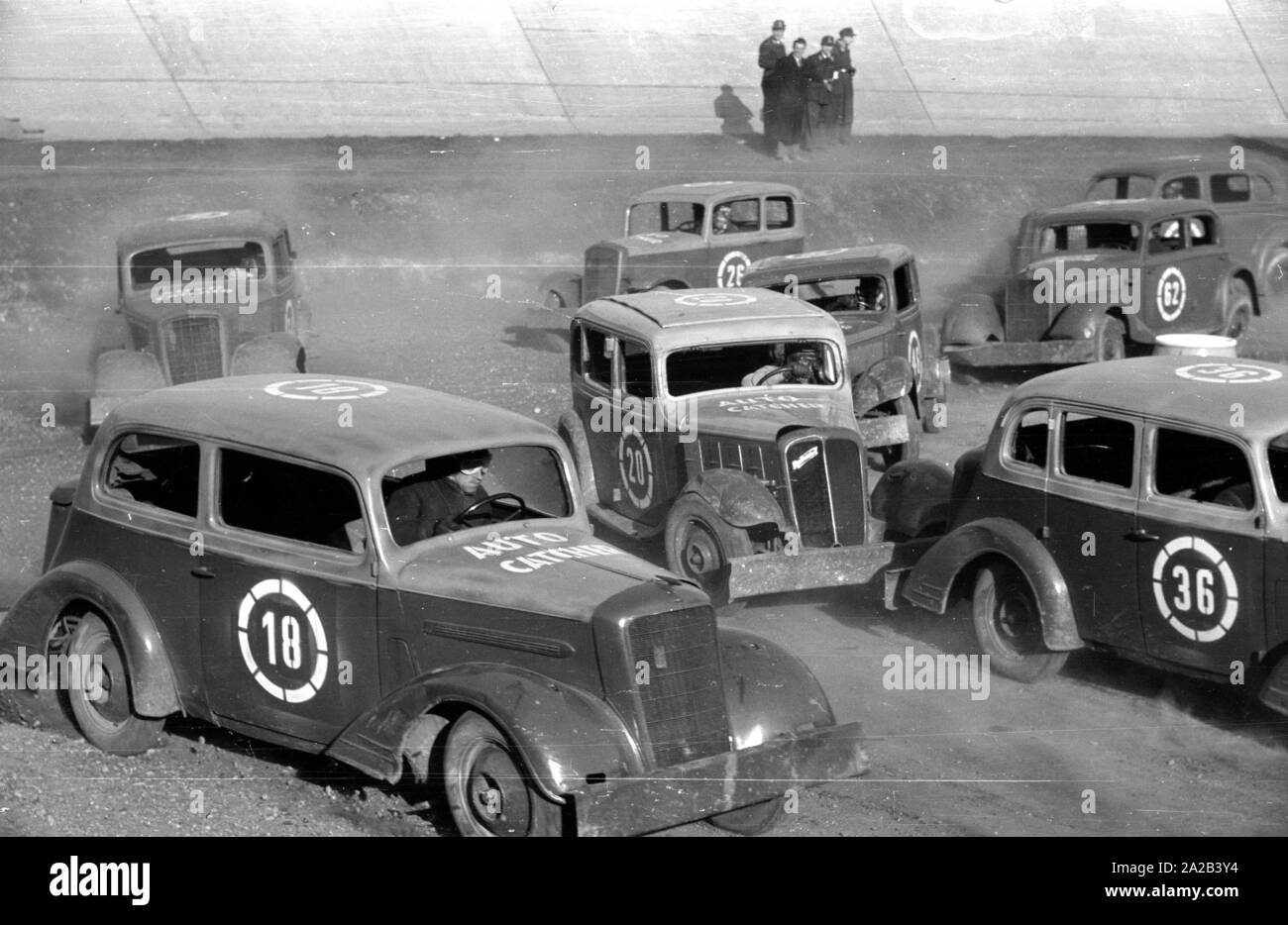 1954 ein Stock Car Rennen statt auf dem Münchner Amor-Bahn (eigentlich ein Radweg). Das Bild zeigt die Teilnehmer während des Rennens, ihre Zahlen wurden auf der Autos besprüht. Die Fahrzeuge waren ältere Modelle (zum Beispiel Hanomag Rekord) in schlechtem Zustand, da sie meistens schwer im Laufe der Rennen beschädigt oder sogar auf dem Schrottplatz nach dem Rennen. Stockfoto