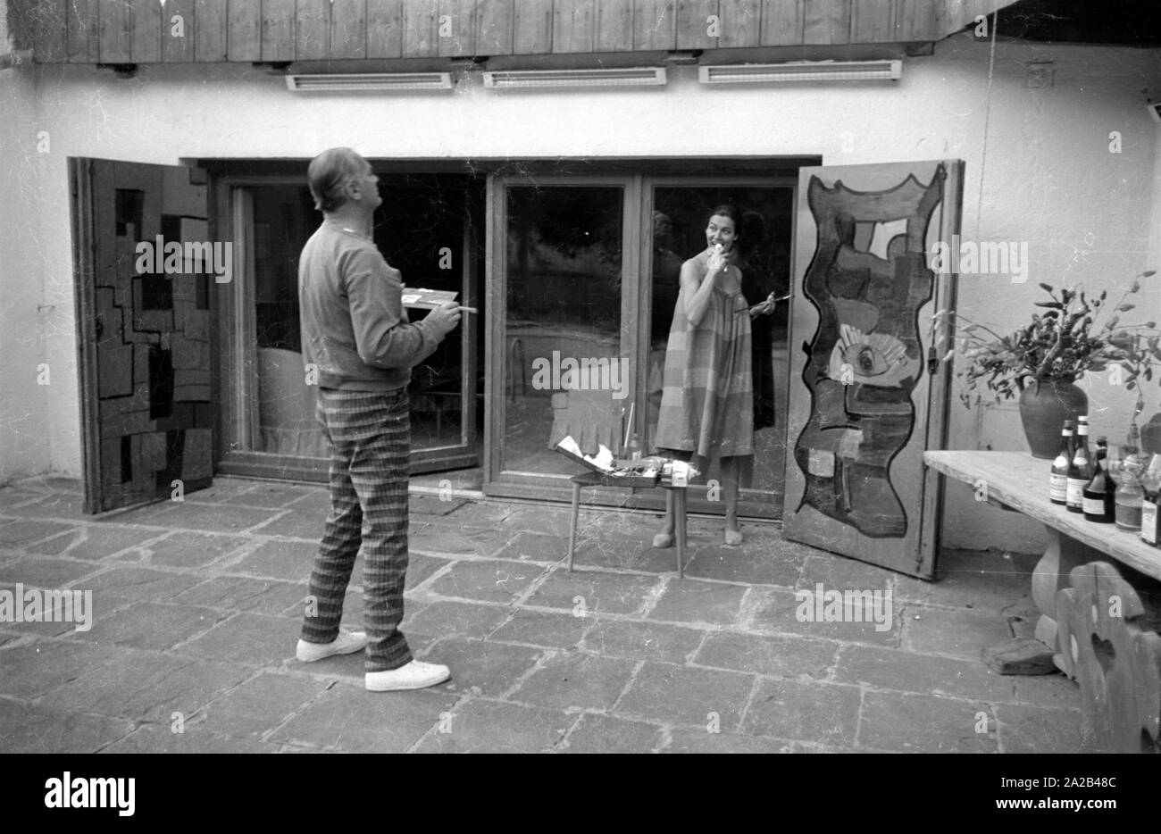 Das Bild zeigt die Schauspieler Curd Jürgens Mit seinem dann - Frau Simone Bicheron beim Malen Zwei große Holztüren. Sie sind wahrscheinlich die Malerei die Türen ihres neuen Immobilien in Villefranche-sur-Mer in Südfrankreich, von Juergens 1959 gekauft. Stockfoto