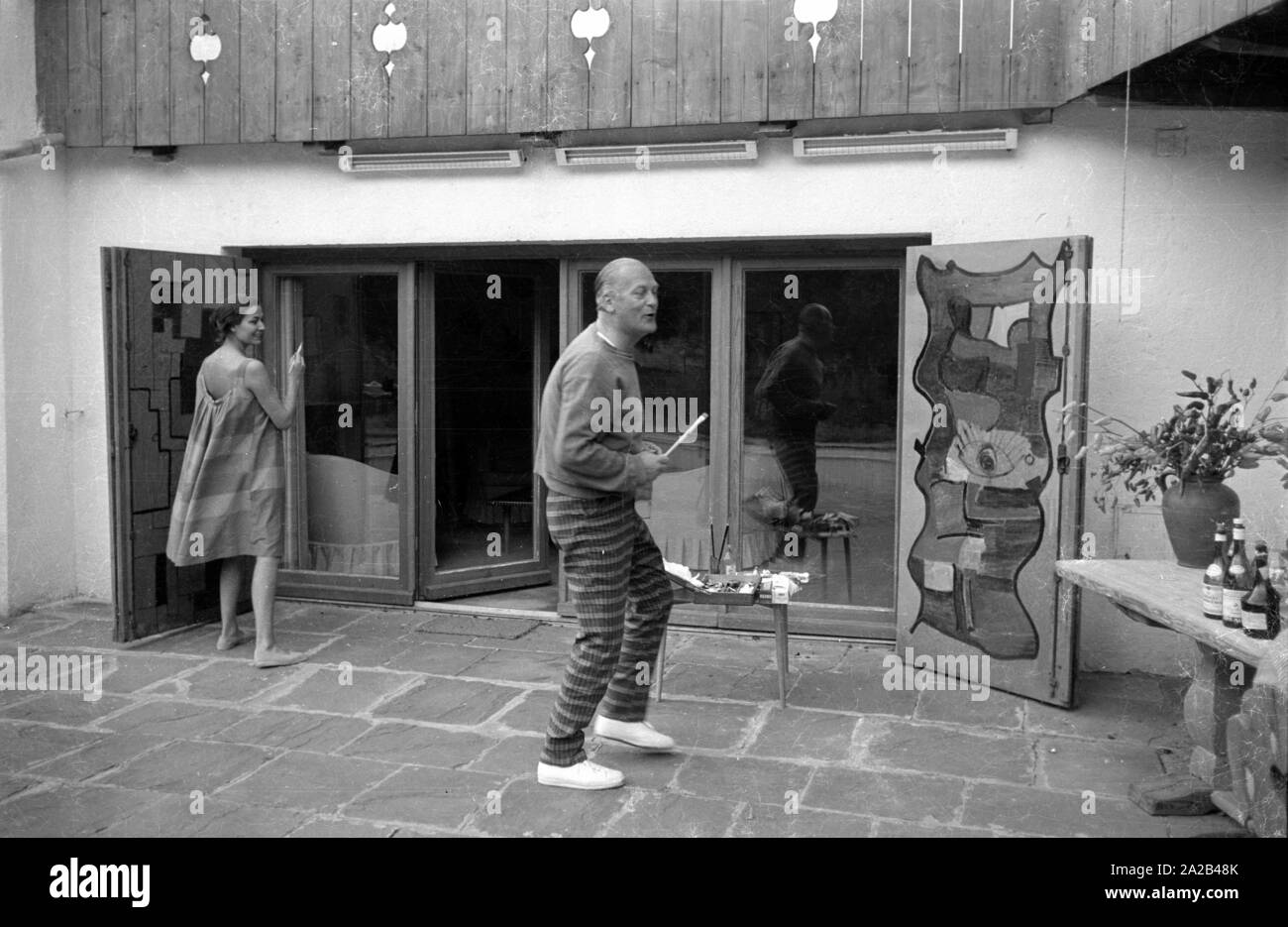Das Bild zeigt die Schauspieler Curd Jürgens Mit seinem dann - Frau Simone Bicheron beim Malen Zwei große Holztüren. Sie sind wahrscheinlich die Malerei die Türen ihres neuen Immobilien in Villefranche-sur-Mer in Südfrankreich, von Juergens 1959 gekauft. Stockfoto