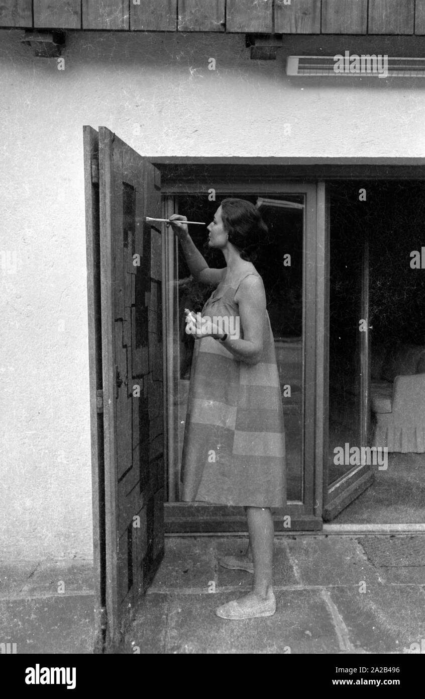 Das Bild zeigt Simone Bicheron, die vierte Ehefrau von Curd Jürgens beim Lackieren von zwei grosse Türen. Sie malte die Türen ihres neuen Immobilien in Villefranche-sur-Mer in Südfrankreich, von Juergens 1959 gekauft. Stockfoto