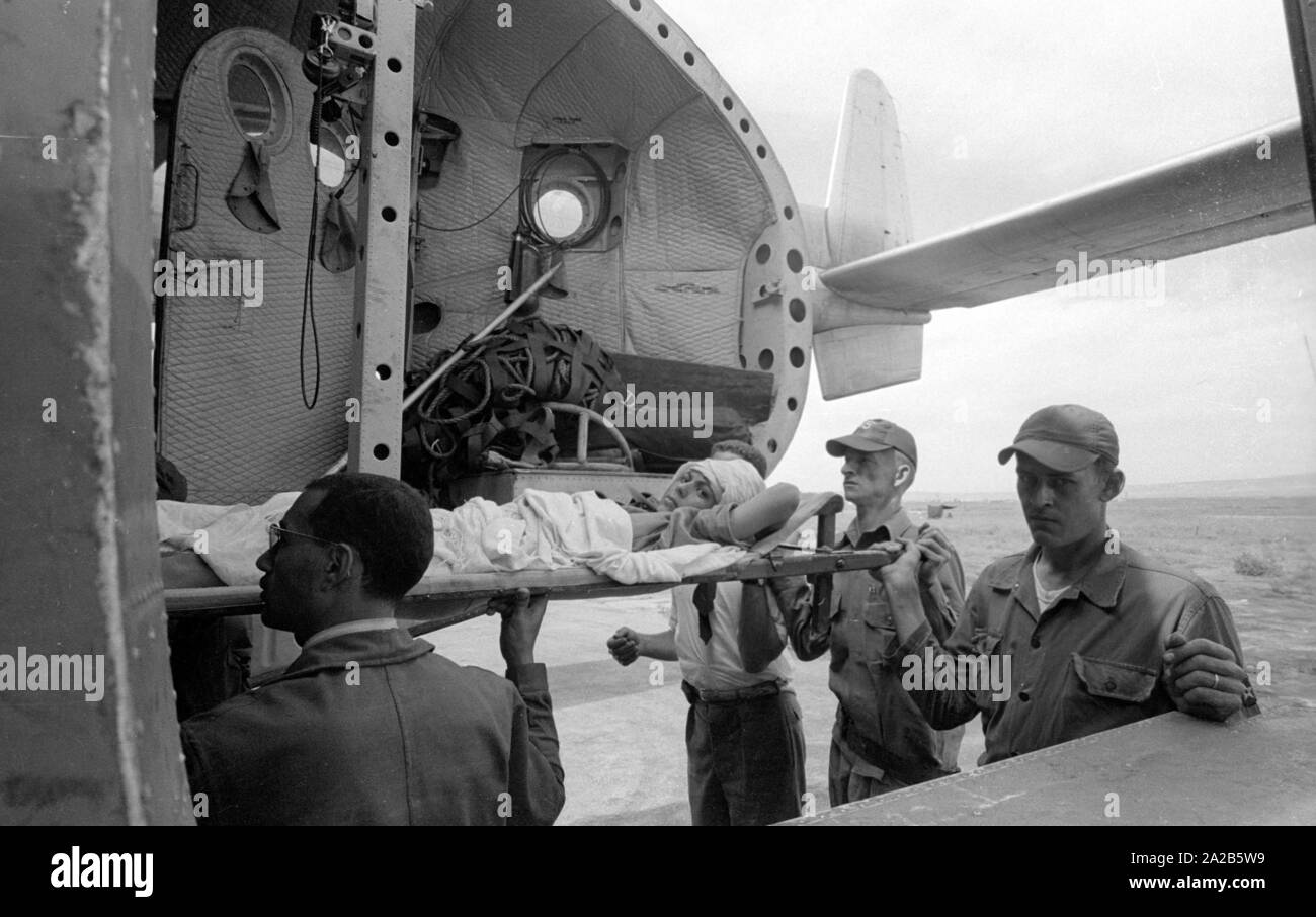 Amerikanische Soldaten laden Sie einen verletzten Mann in ein Verkehrsmittel Flugzeug. Aus dem Bericht 'Erdbeben in Agadir". Die 1960 Agadir Erdbeben zerstört fast die gesamte Stadt und ist die schwerste Naturkatastrophe in der Geschichte Marokkos angesehen. Stockfoto