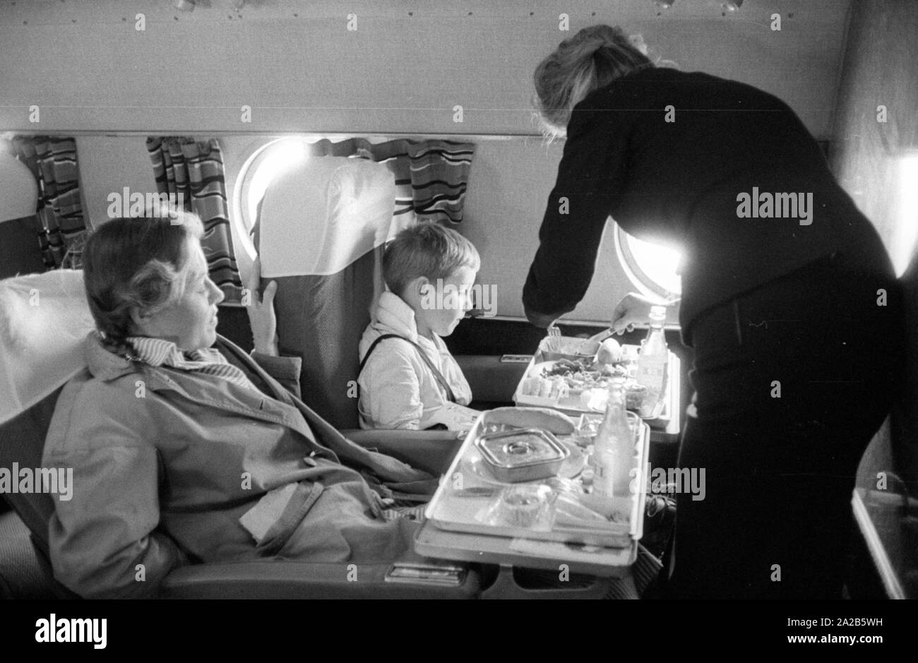 Die Passagiere eines Fluges erhalten eine Mahlzeit serviert. Stockfoto