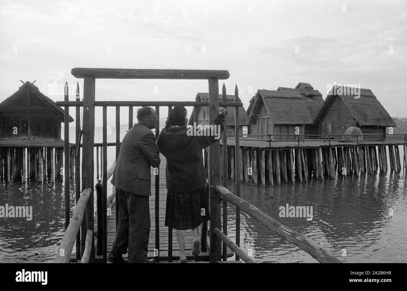 Zwei Menschen stehen vor dem Eingang zum pile-wohnung Dorf am Bodensee. Das Bild zeigt das Freilichtmuseum Unteruhldingen, früher 'Museum deutscher Vorzeit' (Museum für Deutsche Vorgeschichte). Stockfoto